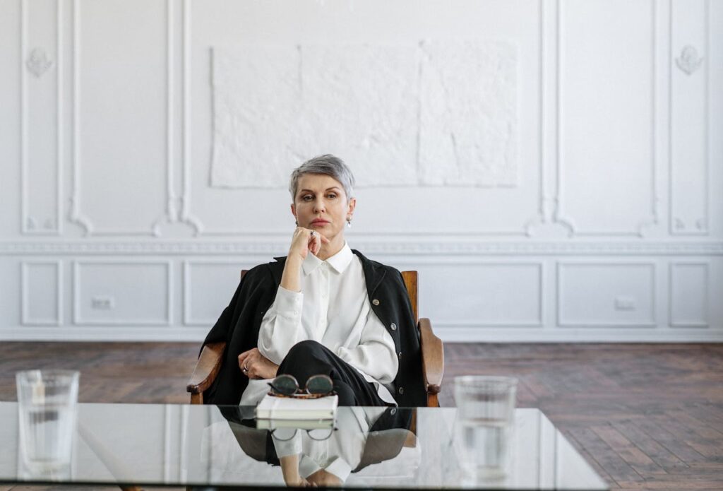 woman in-black-suit-sitting-on-brown-wooden-chair